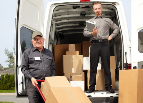 Workers loading furniture safely into a van
