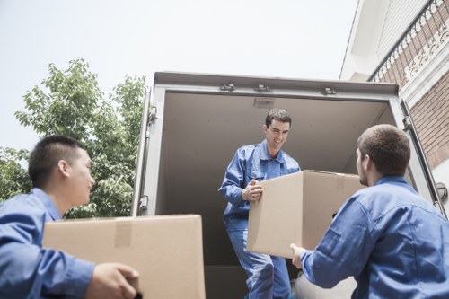 Specialist movers preparing a piano for safe transport through a narrow London staircase